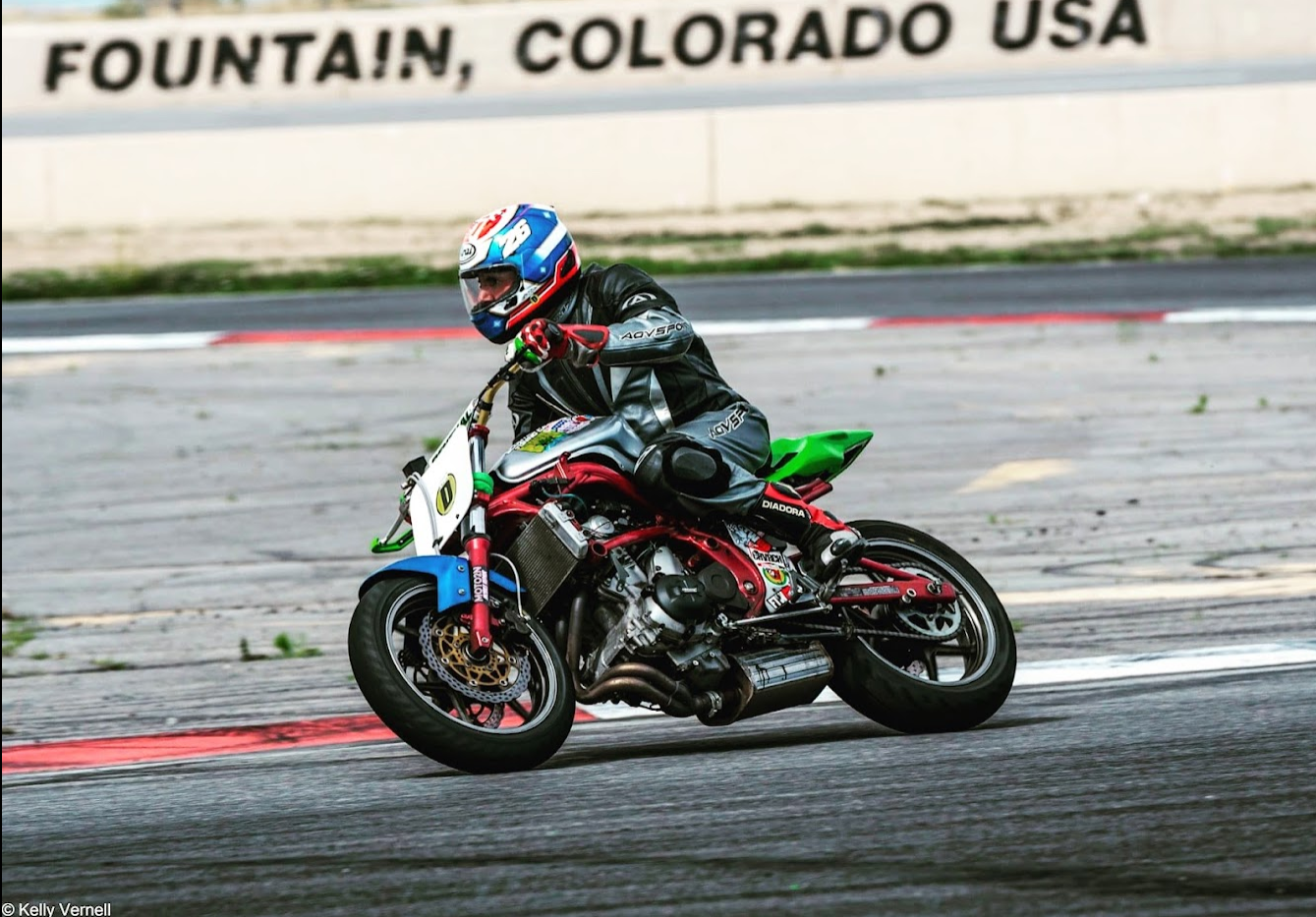 Aston on his Ninja 650 at PPIR. The bike has a blue front fender that matches his helmet and a green tail section.