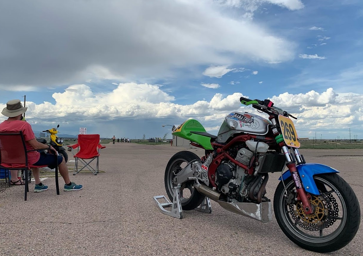 Front right side of naked Ninja 650 racer with blue sky and clouds in the background 