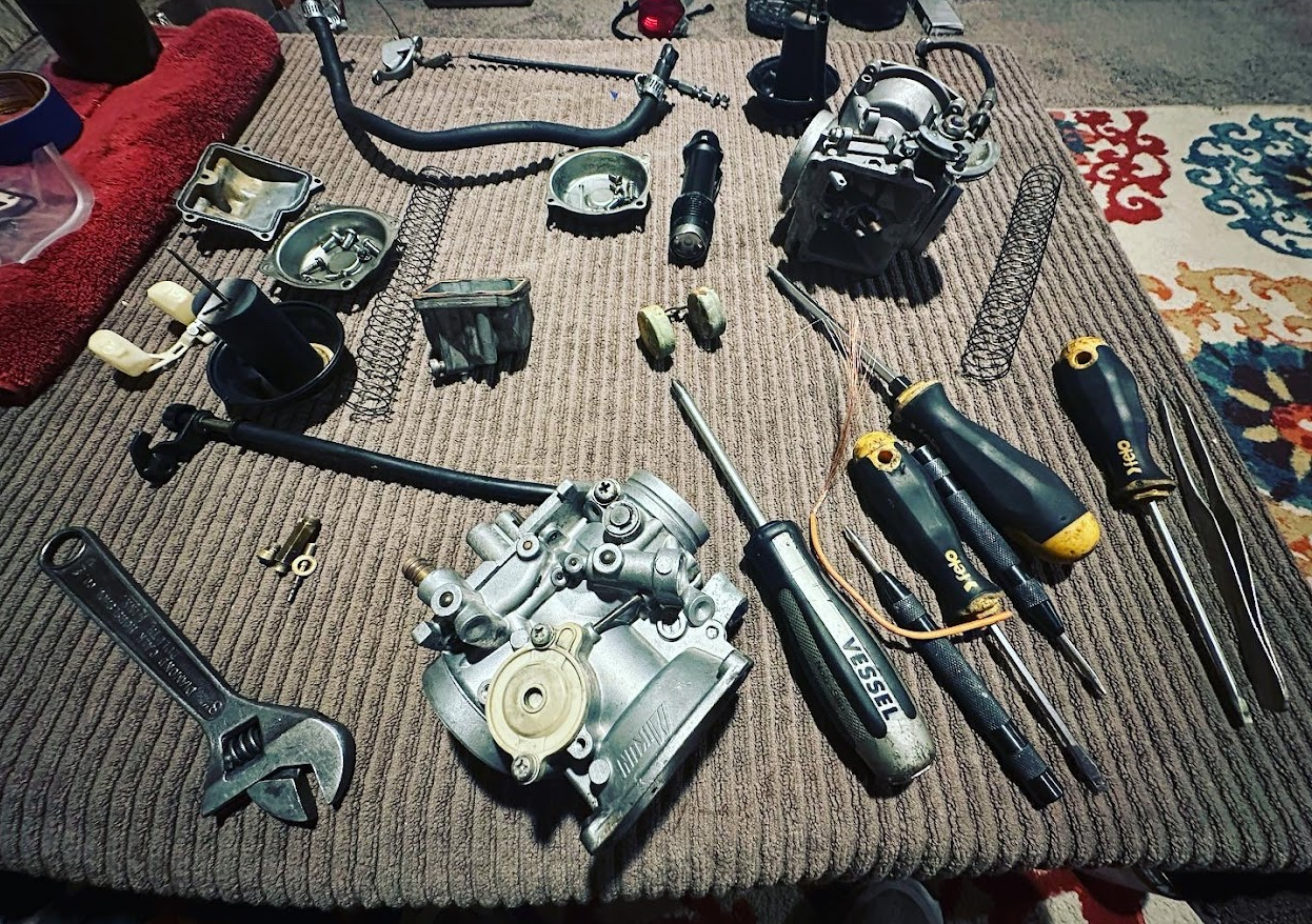 Suzuki Intruder carburetors on a coffee table covered with a brown towel 