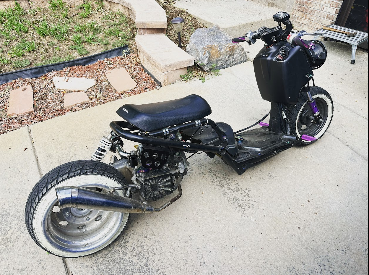 Stretched Honda Ruckus, poorly built in black with whitewall tires