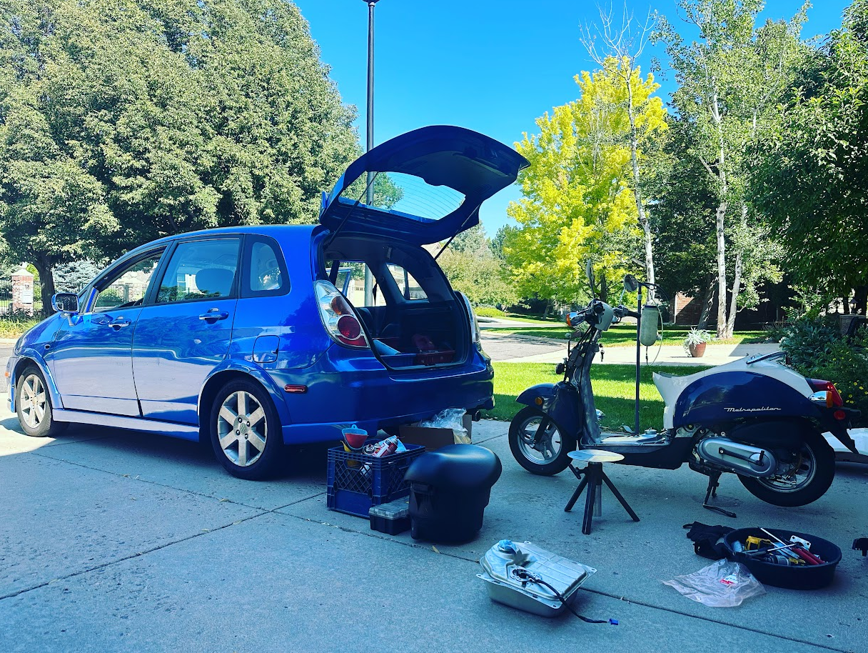 Suzuki Aerio SX service vehicle backed up to a Honda Met in a customer's driveway 