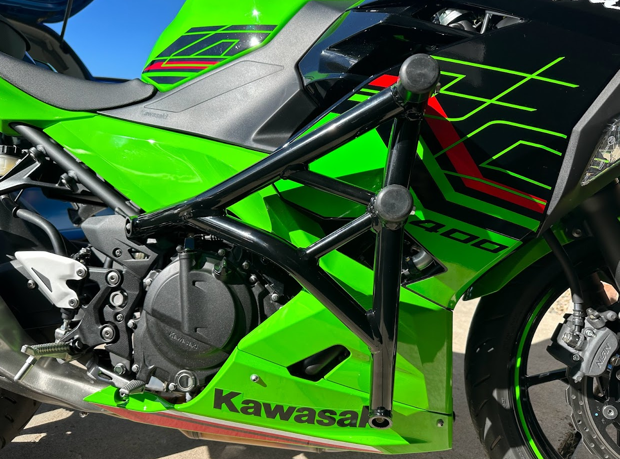 Close up of Impaktech crash cage installed on a green and black Ninja 400